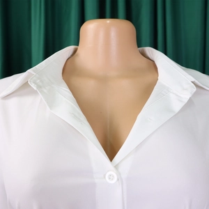 Detail of the white shirt dress showing lapel collar, V-neckline and button closure