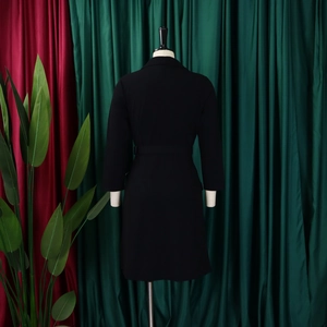 Rear view of a black waist-defining midi blazer dress featuring elegant pleated details