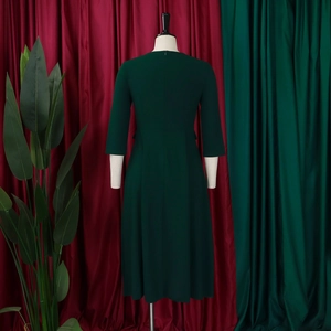 Detail view of dark green midi dress with three-quarter sleeves and hidden back zipper
