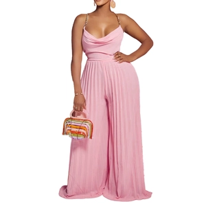 Detail of pink pleated jumpsuit with golden metal chain straps and elegant cowl neckline