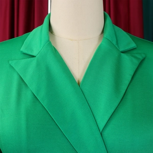 Détail d'une robe vert herbe montrant le col à revers et la texture du tissu sergé