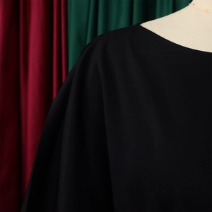 Close-up of the black high-waisted wide-leg jumpsuit with elegant crew neck detail