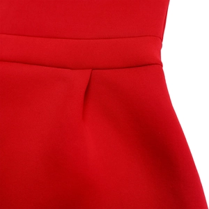 Detail of red party dress showing waist tailoring and premium fabric texture