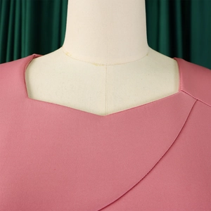 Close-up of pink ruffle dress featuring asymmetrical neckline and twill fabric detail