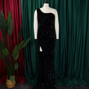 Detailed close-up of the black sequin evening gown with high slit and elegant shoulder cut