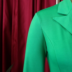 Gros plan du revers d'un blazer vert vif montrant les coutures et la texture du tissu