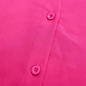 Close-up of deep pink shirt showing resin buttons and fine placket stitching detail
