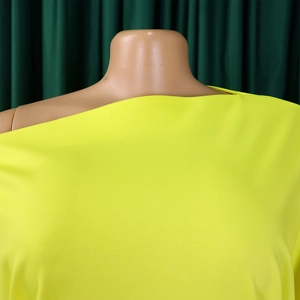 Detail eines neongrünen Oberteils mit schrägem Ausschnitt und strukturierter Strickware