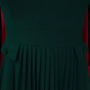 Detailed view of dark green pleated dress featuring a wide waistband and pocket accents