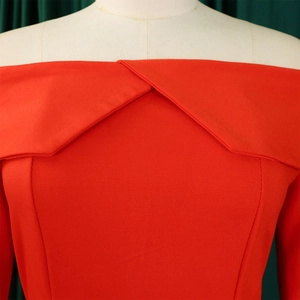 Detail of red off-shoulder neckline with overlapping collar and fine woven texture