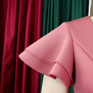 Close-up of elegant double-layered ruffle sleeves on a pale pink solid color dress