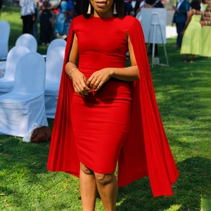 Detail of red slim fit dress featuring pleated cape sleeves and elegant round neckline