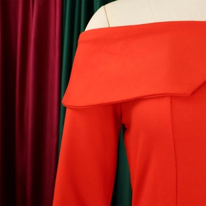 Detail of red off-shoulder collar and textured fabric on an elegant African style suit