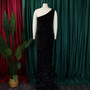 Detail of the black sequined one-shoulder evening gown with shimmering fabric and slit