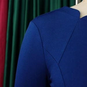 Détail de la robe bleu roi avec encolure en V et coutures contrastées noires sur l'épaule