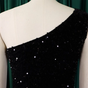 Detail of black sequined one-shoulder evening dress fabric on a mannequin
