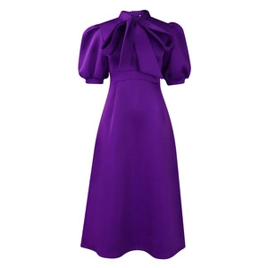 Detail of dark purple dress featuring a large bow neckline and puff short sleeves