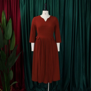 Detail view of brick red pleated midi dress with V-neckline and stylish belt buckle decoration