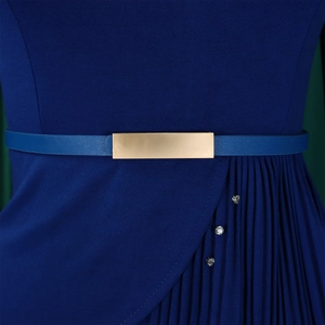 Détail d'une ceinture fine à boucle dorée et de plis sur une robe élégante bleu marine