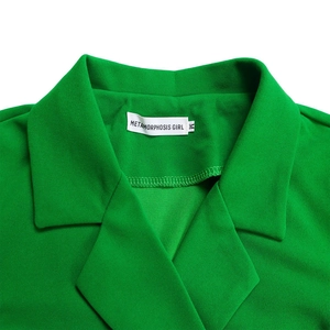 Close-up of green waist-defining blazer dress featuring lapel collar and textile neck label