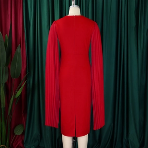 Detail of the red dress showing the long pleated sleeves and the concealed back zipper