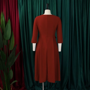 Rear view of a burnt orange midi dress with 3/4 sleeves and hidden zipper closure detail