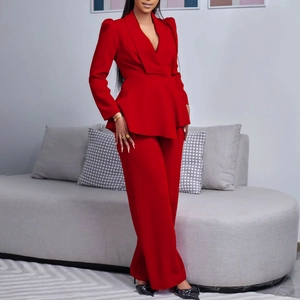 Detail of red two-piece suit showing ruffled waistline and long sleeve blazer texture
