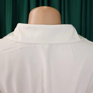 Detail view of the white button-up shirt dress back collar and fabric texture
