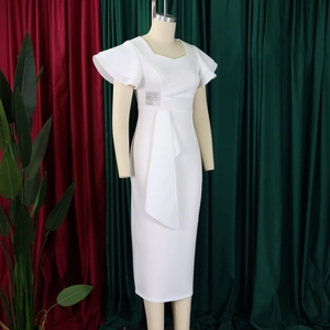 Close-up of elegant white ruffled dress featuring a sparkling rhinestone buckle and pleats