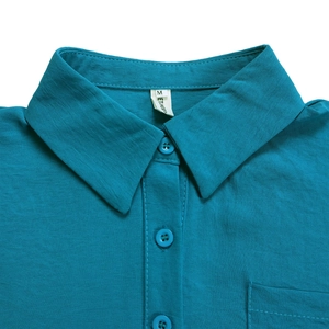 Close-up of a teal lapel collar shirt showing linen texture and matching buttons