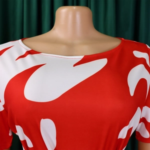Détail de l'imprimé abstrait rouge et blanc sur robe à manches courtes avec col de qualité