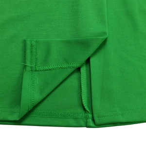 Detail view of the hem slit and professional double stitching on the green pencil dress