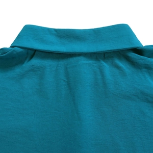 Close-up detail of the lapel collar and linen fabric texture on this teal blue summer shirt