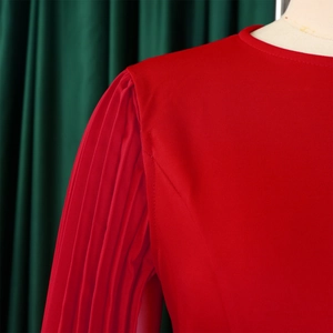 Detail view of red pleated accordion sleeves and high-density fabric on a round neck dress