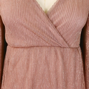 Detail view of pink shimmer fabric with vertical pleats and elegant V-neckline design