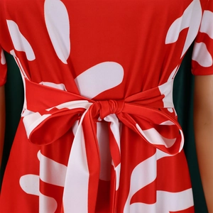 Détail de la robe imprimée rouge et blanc avec une élégante ceinture à nœud à la taille