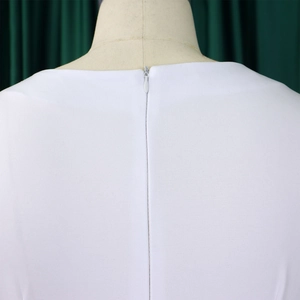 Détail de la robe blanche présentant une fermeture éclair invisible et une texture tissée