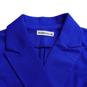 Détail de la robe blazer bleu roi avec revers en pointe et texture de tissu en sergé premium