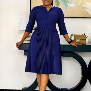Detail of navy blue dress with V-neckline, 3/4 sleeves and elegant pleated skirt hem