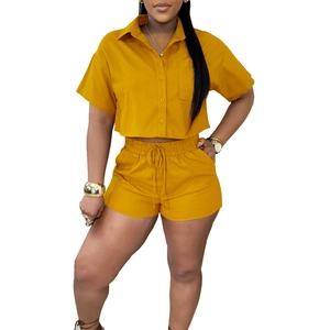 Detail of ginger yellow linen-style shirt with front pocket and drawstring shorts