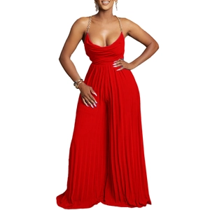 Detail of red pleated jumpsuit featuring golden chain halter neck and deep V-neckline