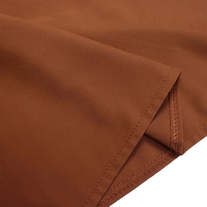 Detail view of double-needle stitching and fabric texture on a rust red summer dress