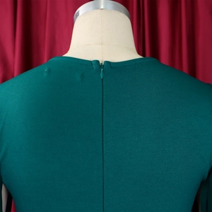 Macro detail of high-quality invisible zipper on the dark green textured evening dress