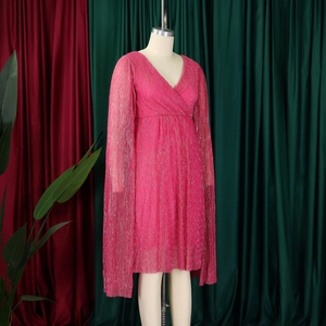 Detail of rose red pleated V-neck dress featuring unique cape sleeves and shimmering fabric