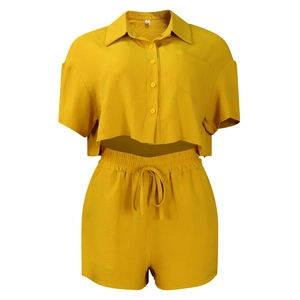 Detail view of mustard yellow short sleeve button-up shirt and elastic waist shorts set