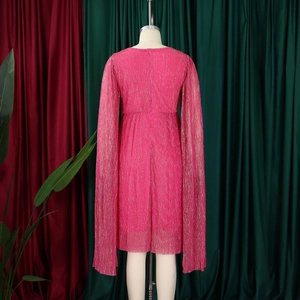Detailed texture of rose red pleated long sleeve dress with metallic shimmering fabric
