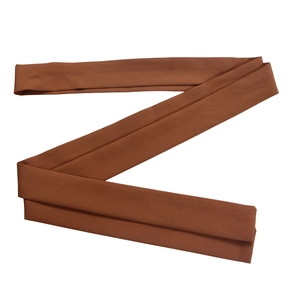 Detail shot of the caramel brown woven fabric belt with fine stitching and matte texture