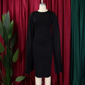 Close-up of elegant pleated cape sleeves on a slim-fit black formal evening dress