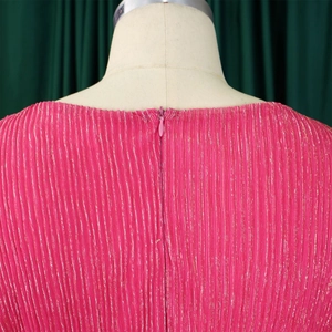 Macro detail of pink pleated fabric with gold metallic thread and hidden zipper