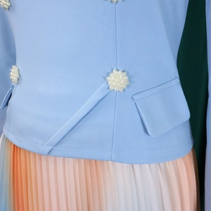 Detail of light blue blazer with pearl flowers and gradient pleated skirt ensemble